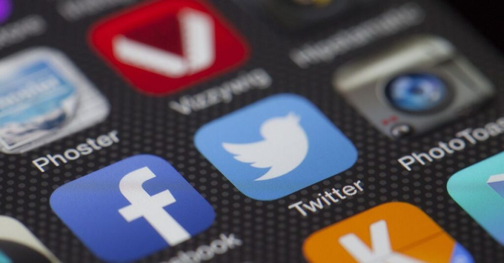 ブログ記事をSNSでシェアしているブロガー。TwitterやInstagramの投稿画面を操作している様子。